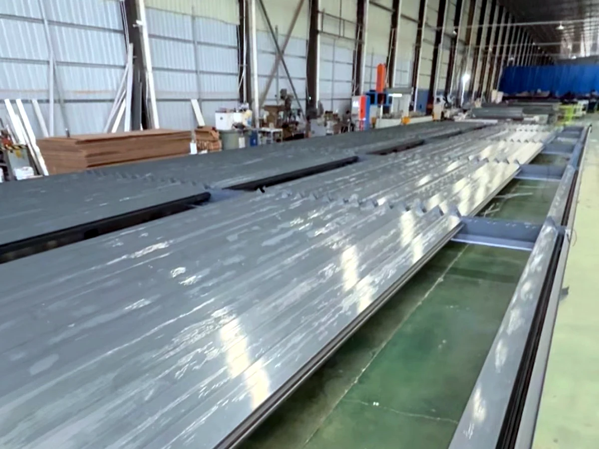 Aluminum pergola profiles and components organized on the factory floor